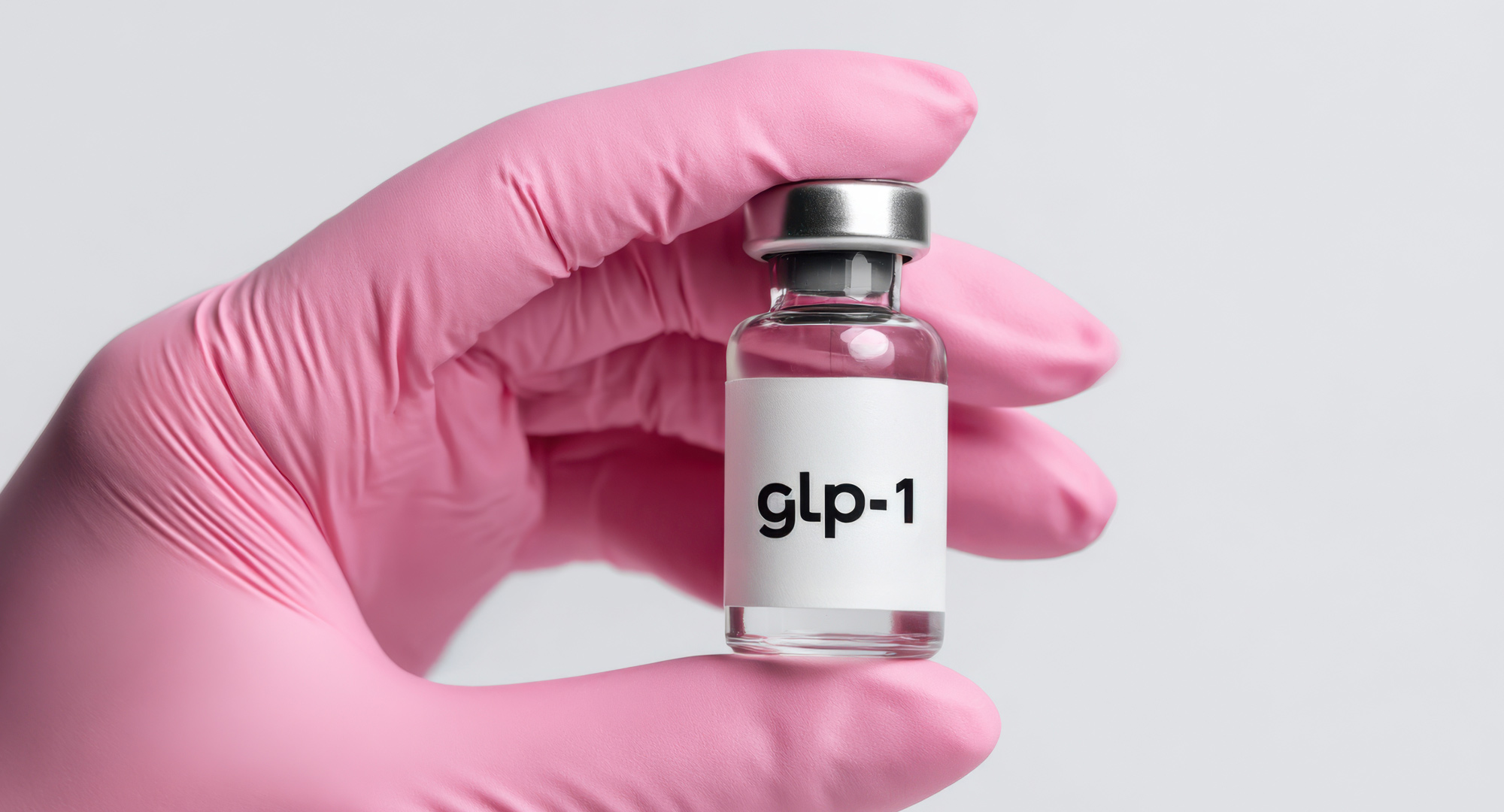 Hand in a pink glove hold ing a GLP-1 vial
