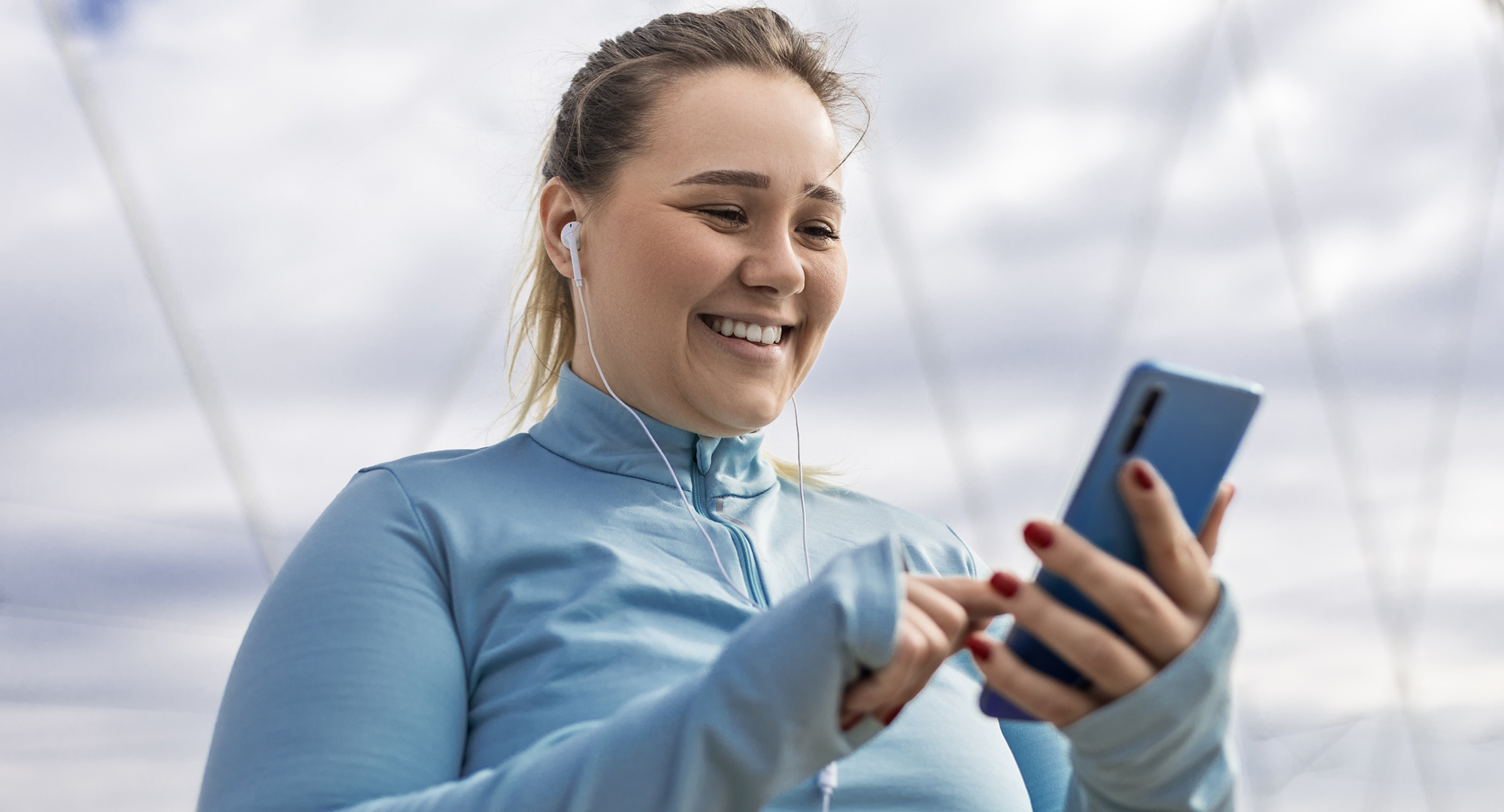 A woman in exercise clothes looking at her smartphone