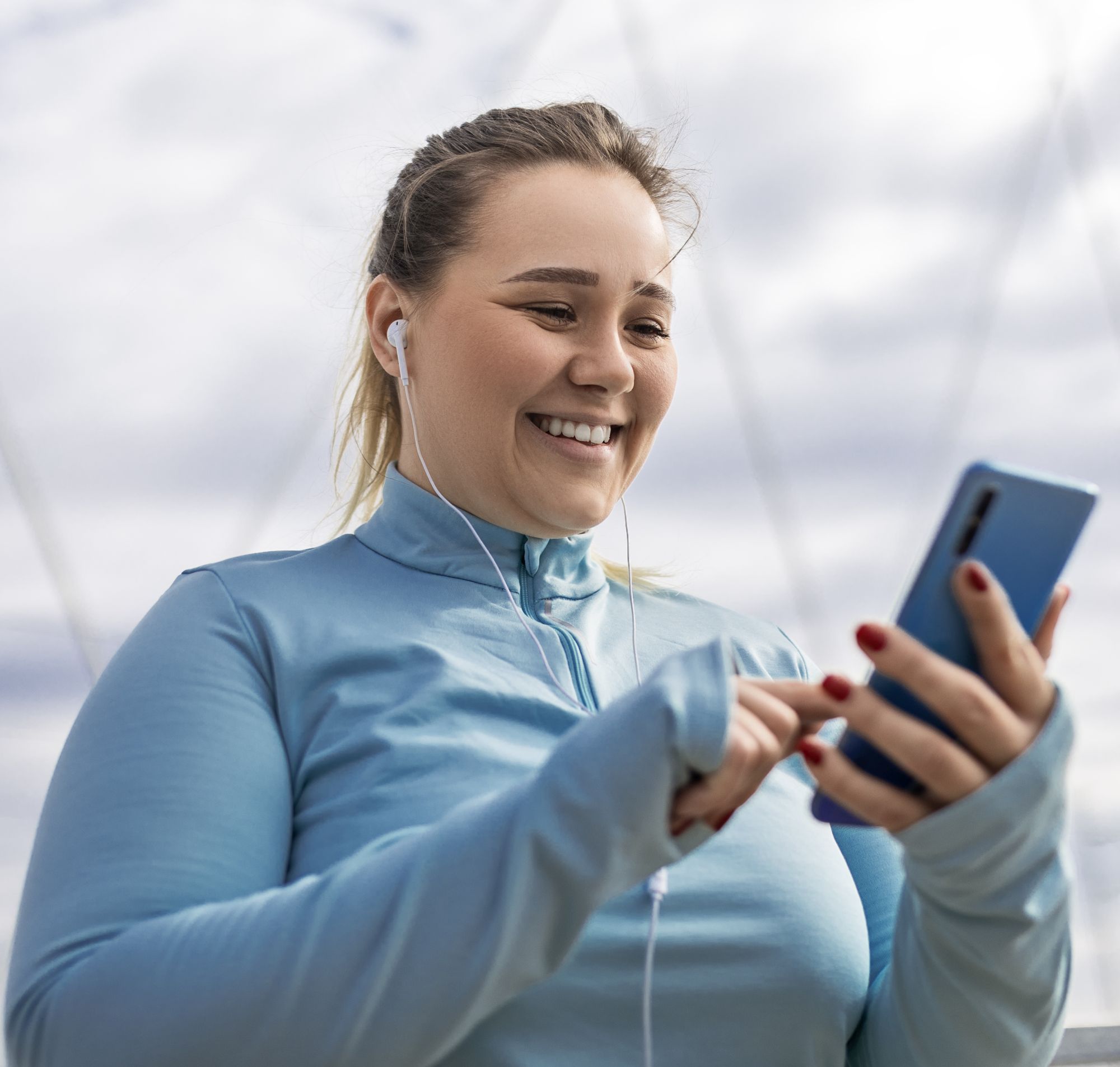 A woman in exercise clothes using her smartphone