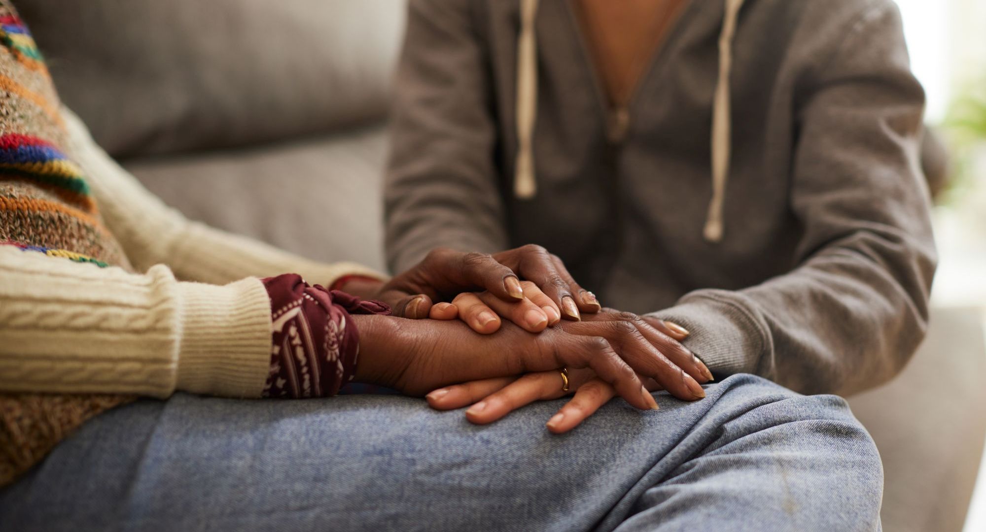 Two people holding hands and comforting each other